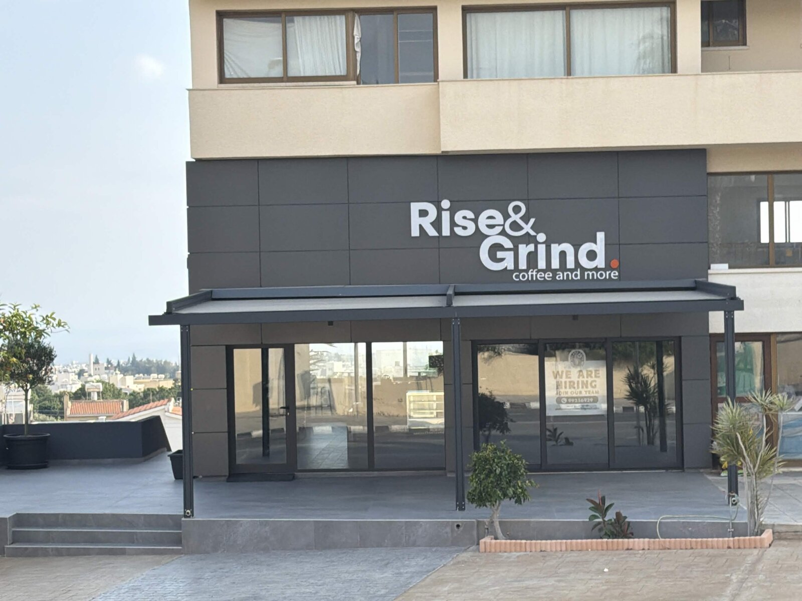 Rise & Grind coffee shop storefront with covered seating in Anavargos, Paphos